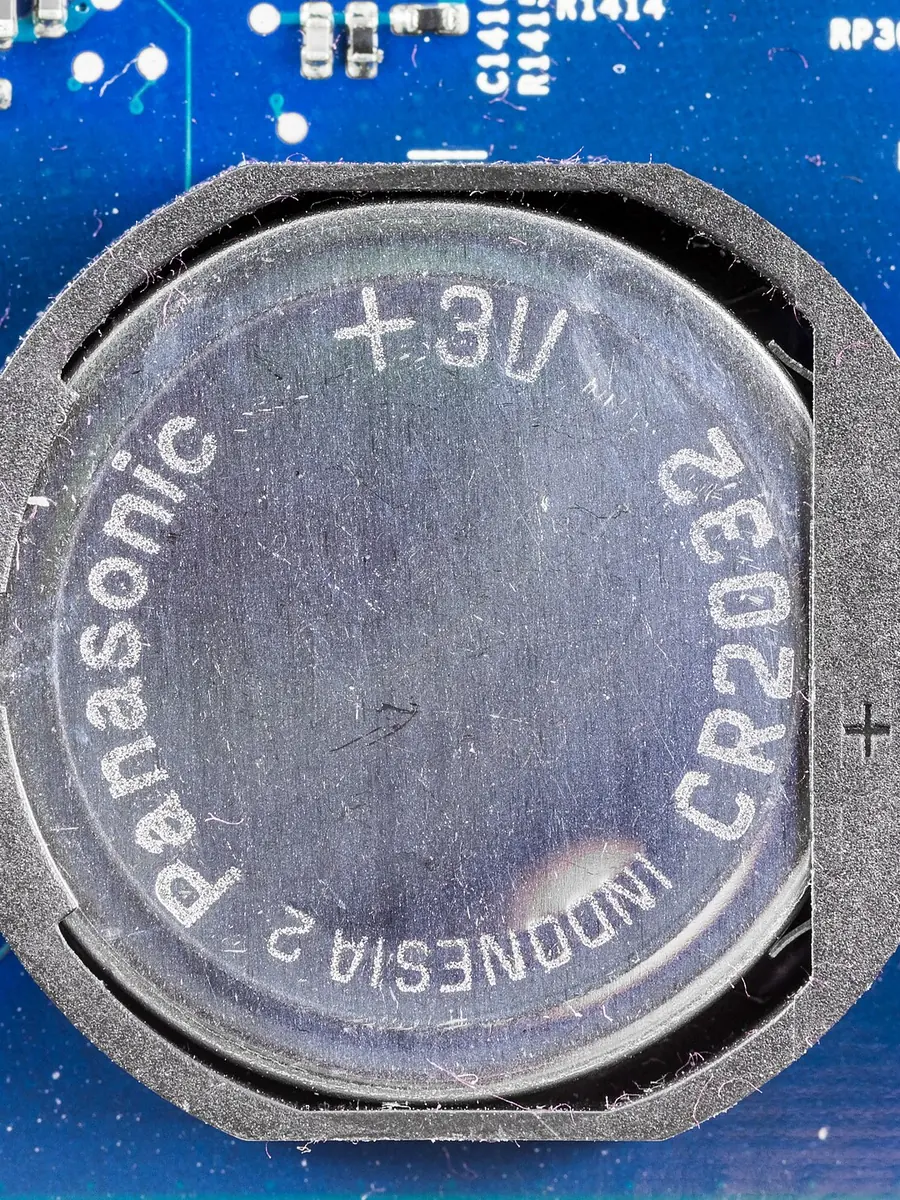 A CR2032 coin cell held in a clip on a circuit board