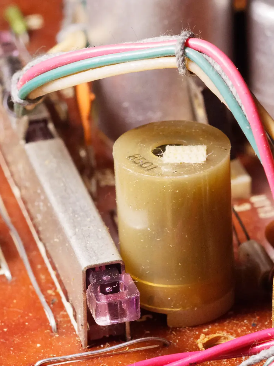 A wound inductor on a circuit board between coloured wires