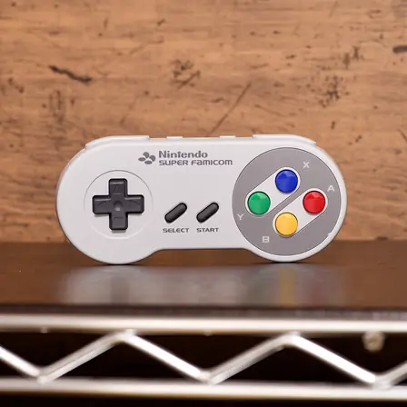 A Super Famicom controller resting on a wooden surface